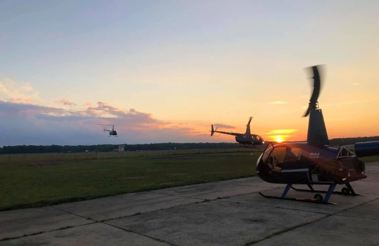 Helikoptery na polu o zachodzie słońca